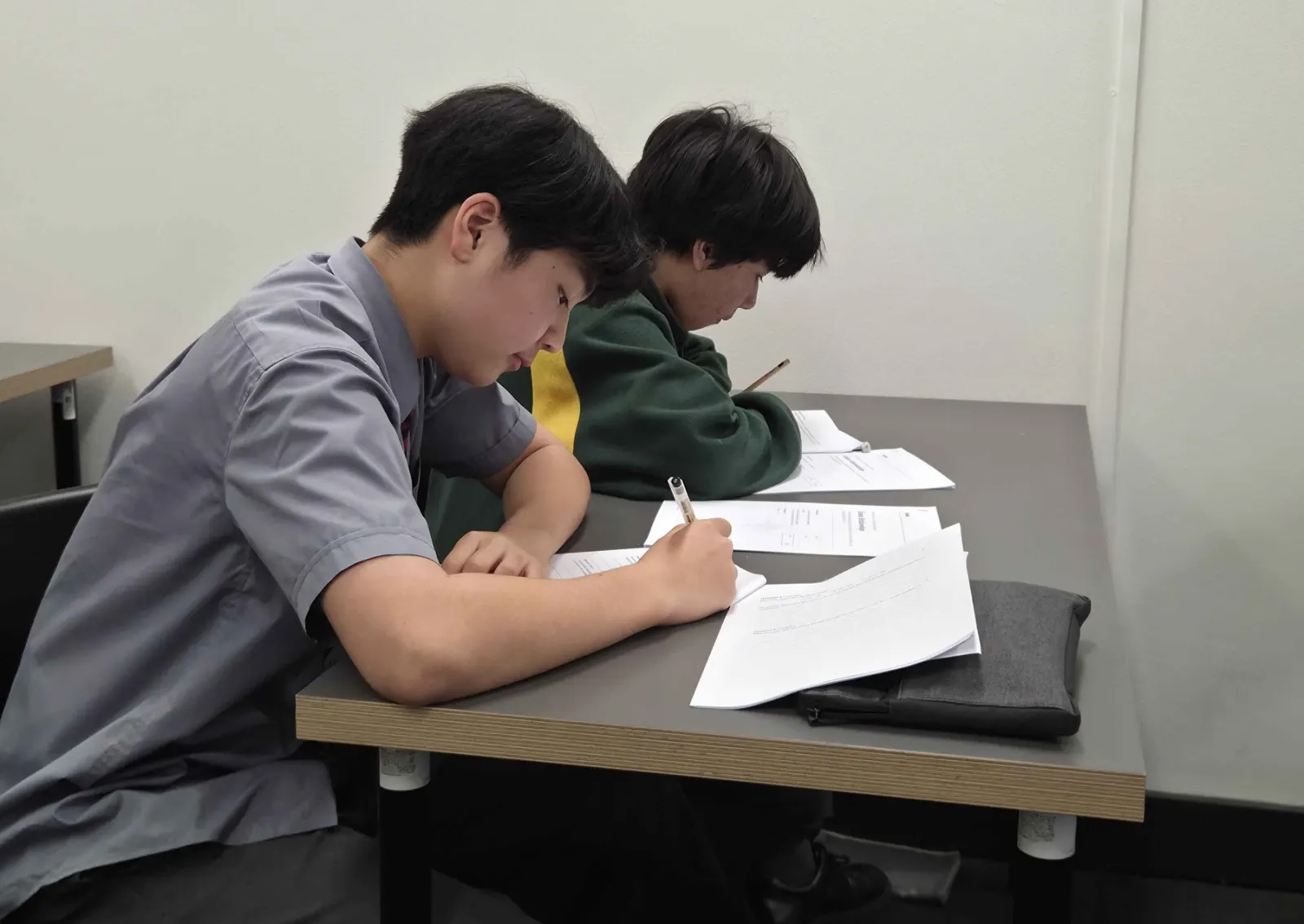 Two BEAM students working through their printed lesson materials