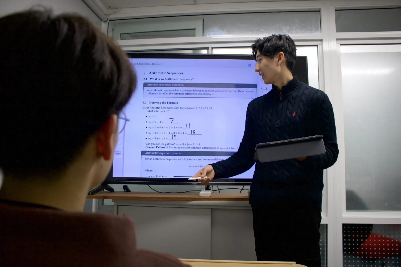 A BEAM tutor explaining arithmetic sequences on the classroom screen